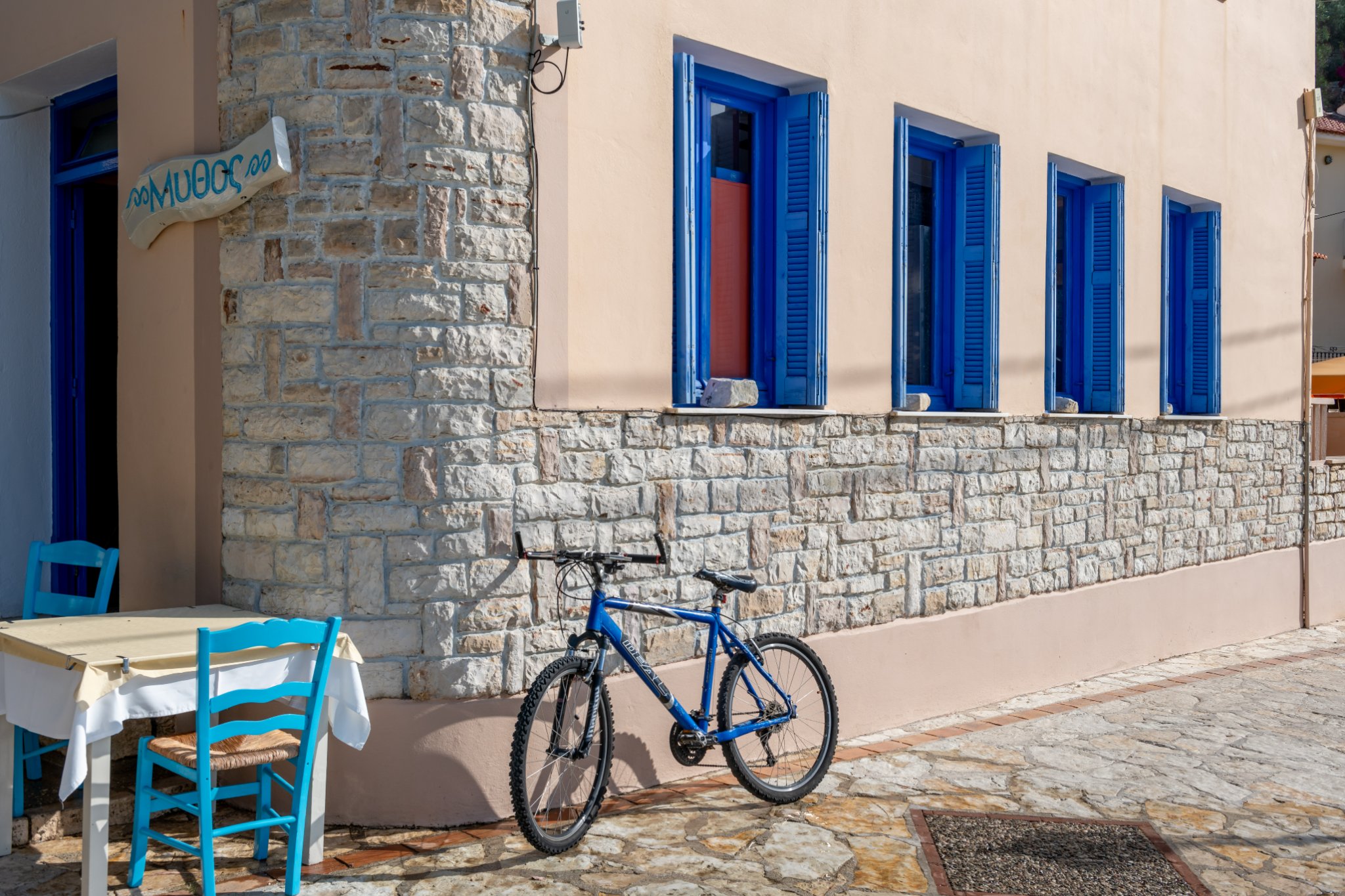 Blue bicycle in front of a stone house